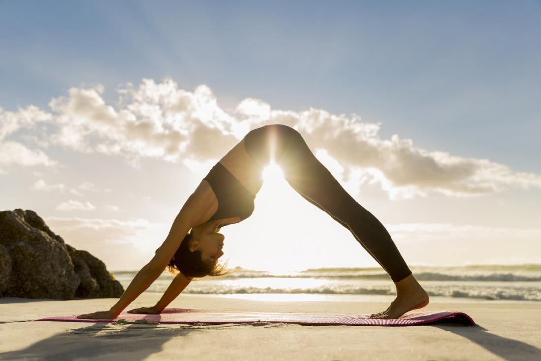 a-woman-practicing-yoga-on-the-beach YOGA